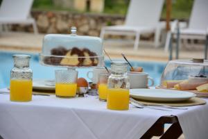 uma mesa com sumo de laranja e uma cesta de comida em Elianthos Villas em Vámos