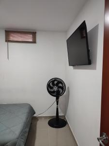 Habitación con cama, ventilador y TV. en 302-Cómodo y moderno apartamento de 2 habitaciones en la mejor zona céntrica de Ibagué, en Ibagué