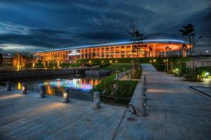 a building with a pond in front of it at night at NH Homestay Trefoil Setia Alam in Shah Alam