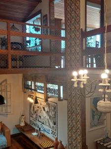 a living room with windows and a chandelier at Casa de Praia Alameda Azul in Guarapari