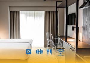 una habitación de hotel con una cama y un televisor en Sandton Eindhoven Centre - Private parking, en Eindhoven