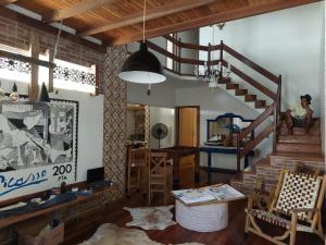 una sala de estar con una escalera y una persona sentada en una silla en Casa de Praia Alameda Azul, en Guarapari