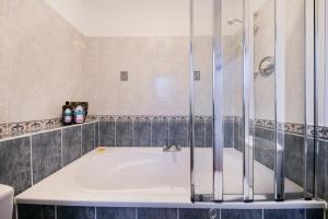 uma casa de banho com banheira e chuveiro em Castle Street Apartments ✪ Grampian Lettings Ltd em Aberdeen