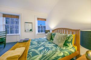 ein Schlafzimmer mit einem Bett und einer Couch und Fenstern in der Unterkunft Castle Street Apartments ✪ Grampian Lettings Ltd in Aberdeen