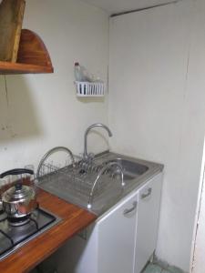 a kitchen with a sink and a stove at Cabañitas Remanso, baño privado in Isla de Maipo