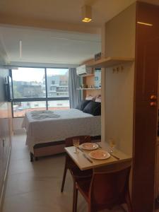 a small room with a bed and a table with a table sidx sidx at Luar Porto de Galinhas in Porto De Galinhas