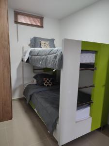 - une chambre avec deux lits superposés et un petit lit dans l'établissement 302-Cómodo y moderno apartamento de 2 habitaciones en la mejor zona céntrica de Ibagué, à Ibagué