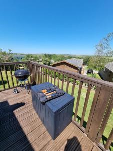 a wooden deck with a table and a grill at Bella View - Newquay - White Acres in Newquay