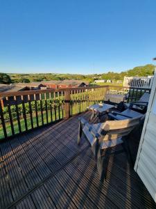 a deck with a table and chairs on it at Bella View - Newquay - White Acres in Newquay