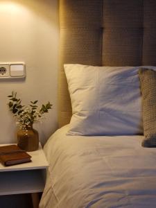 a bed with a pillow and a table with a book at Cozy apartment in the city center in Granada