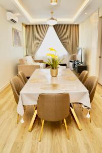 a dining room with a white table and chairs at Casa Callisto Homestay - New Seaview with pool 3BR Apartment Ladang Tanjung in Kuala Terengganu