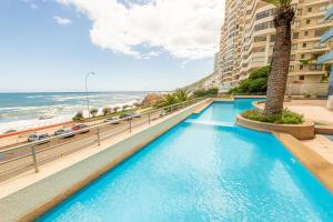 uma piscina com vista para a praia e edifícios em Oceana Suites Eurovista em Viña del Mar