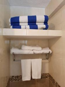 łazienka z białymi i niebieskimi ręcznikami w obiekcie Acapulco diamante departamento con playa ecológico w Acapulco