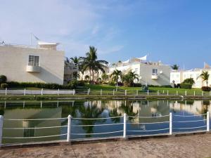 a body of water with a fence and houses at Acapulco diamante departamento con playa ecológico in Acapulco