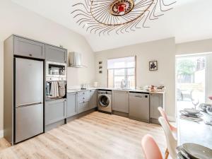 a kitchen with a refrigerator and a table with chairs at Cattle Crush Cottage - Uk35988 in Great Driffield