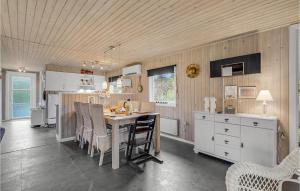 a kitchen with a table and chairs in a room at 3 Bedroom Amazing Home In Oksbøl in Oksbøl
