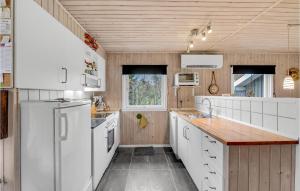 a kitchen with white appliances and a wooden ceiling at 3 Bedroom Amazing Home In Oksbøl in Oksbøl +17 photos