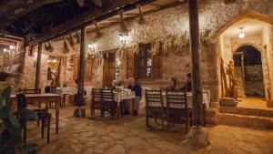 a group of people sitting at tables in a restaurant at Hoyran Wedre Country Houses in Davazlar