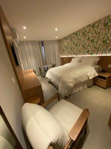 a hotel room with a bed and a chair at Pousada Flor de Anis in Alto Paraíso de Goiás
