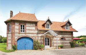 una vieja casa de ladrillo con un garaje azul en 6 Bedroom Awesome Home In Hericourt-en-caux, en Héricourt-en-Caux