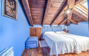 Habitación con 2 camas, paredes azules y techos de madera. en Gorgeous Apartment In Fonsagrada With Kitchen, en Fonsagrada