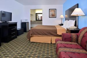 a hotel room with a bed and a tv at Executive Inn in Edmond