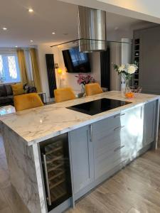 a kitchen with a large island in a living room at Luxury Modern house Open Plan Living Space&hottub sleeps 6 in Penmaen-mawr