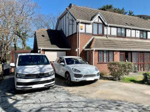 two cars parked in a driveway in front of a house at Luxury Modern house Open Plan Living Space&hottub sleeps 6 in Penmaen-mawr