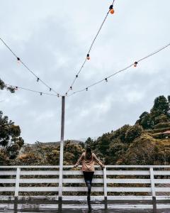 a woman walking across a bridge with lights at Capivari Lodge in Campos do Jordão