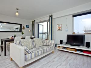 a living room with a couch and a tv at Apartment 7, Ocean 1 in Crantock