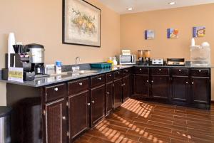 a kitchen with wooden cabinets and a counter top at Executive Inn in Edmond