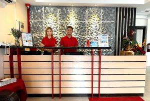 長灘島的住宿－長灘島紅可可旅館，站在柜台后面的男人和女人