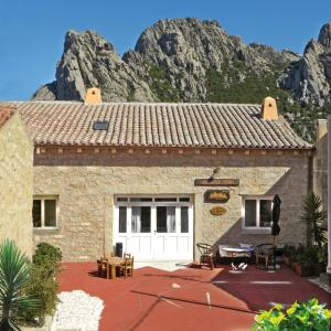 a building with a mountain in the background at Antica Dimora La Corona in San Pantaleo