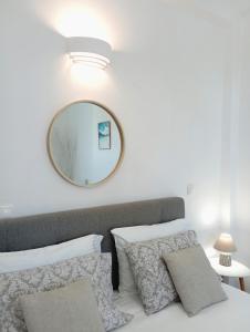 a bedroom with a mirror and a bed with pillows at Apanema Paros in Naousa