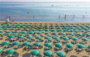 una vista aérea de una playa con sombrillas verdes en Aurora, en Orciano di Pesaro