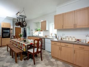 a kitchen with a table and chairs and a kitchen with white appliances at Ranscombe House in Brixham