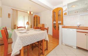 a kitchen and dining room with a table and chairs at Stunning Home In Povile With Wifi in Povile