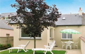 un grupo de sillas y un paraguas en un patio en Gorgeous Home In Trévou Treguignec, en Trévou-Tréguignec