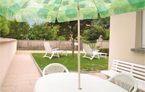 Una mesa con sillas y una sombrilla en un patio. en Gorgeous Home In Trévou Treguignec, en Trévou-Tréguignec 11 fotos más