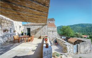 un edificio de piedra con una mesa y sillas en un patio en 3 Bedroom Gorgeous Home In Mrcevo en Mrčevo