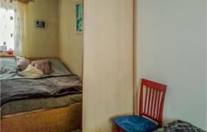 ein Schlafzimmer mit einem Bett und einem roten Stuhl in der Unterkunft 3 Bedroom Amazing Home In Parzensko in Nowogródek Pomorski