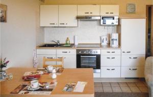 a kitchen with white cabinets and a wooden table at Cozy Apartment In Medebach-Düdinghausen in Medebach