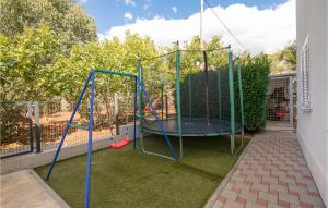 a trampoline in a yard with a fence at 4 Bedroom Amazing Home In Vinjani Donji in Imotski