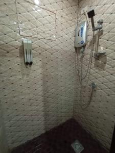 uma casa de banho com um chuveiro e um telefone na parede em 7 Meadows Inn em Tagbilaran