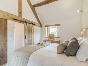 a bedroom with a large white bed with pillows at Riverside Dairy in Bamford