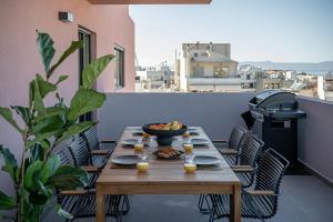 a wooden table with a bowl of fruit on a balcony at Sea & Sun Penthouse in Chania