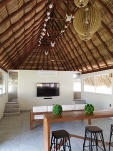 a living room with a table and chairs and a tv at Acapulco diamante departamento con playa ecológico in Acapulco