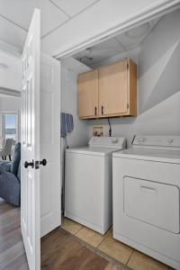 a white laundry room with a washer and dryer at Lakefront: Dock, Hot Tub, Fire Pit & Home Theater in Winchester