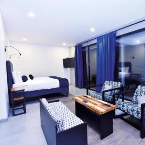 une chambre d'hôtel avec un lit, une table et des chaises dans l'établissement Hotel Colinas Altavista, à Tarbaca