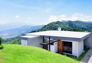 une maison au sommet d'une colline herbeuse dans l'établissement Hotel Colinas Altavista, à Tarbaca